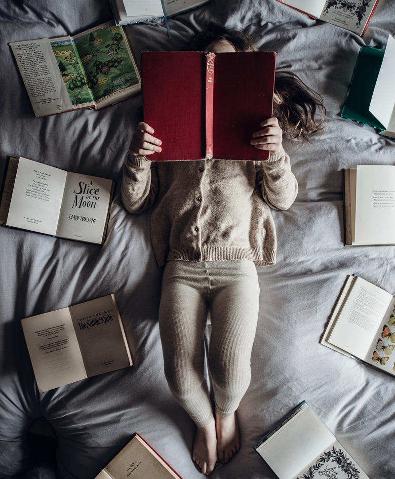 12 Ways to Add More Joy to Your Book-Reading Bliss, woman in long johns reading 9 books in bed