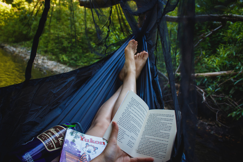 12 Ways to Add More Joy to Your Book-Reading Bliss, woman in hammock reading book in woods